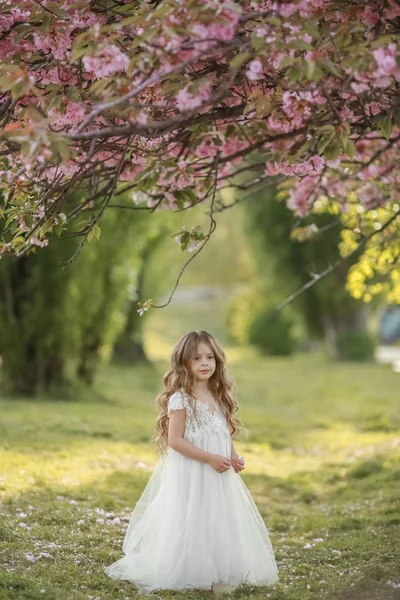 A menina no parque correndo e brincando vestida com longos vestidos brancos como uma noiva — Fotografia de Stock