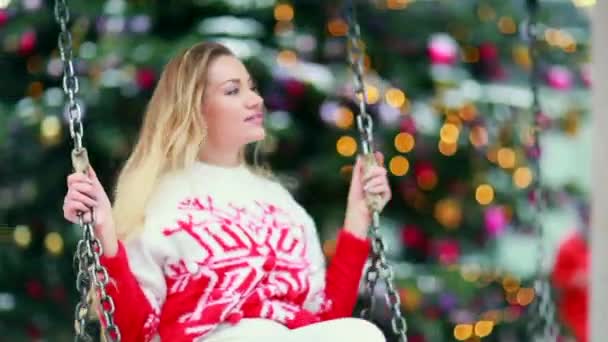 Chica en un jersey rojo de Navidad en el columpio — Vídeo de stock