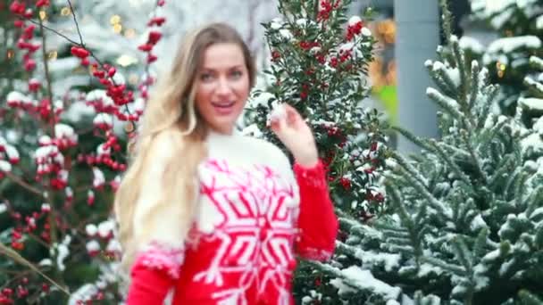 Uma menina em uma camisola de Natal vermelho brinca com neve — Vídeo de Stock