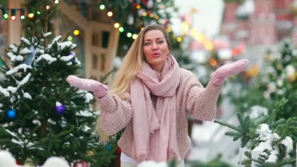 Blondine mit langen Haaren an einem Neujahrstag im Hintergrund einer geschmückten Stadt — Stockvideo