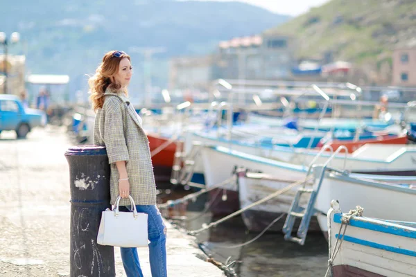 Молодая красивая модель во время прогулок по заливу с припаркованными яхтами — стоковое фото