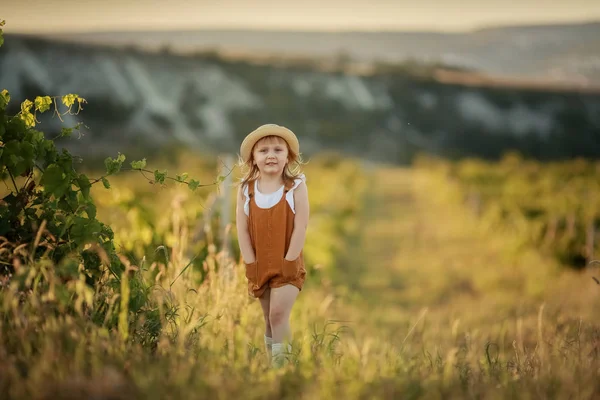 Kleines Mädchen läuft auf grünem Gras. schöner warmer Sommerabend. — Stockfoto