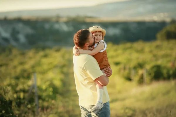 The father lovingly holds his daughter in his arms and hugs her — Stock Photo, Image