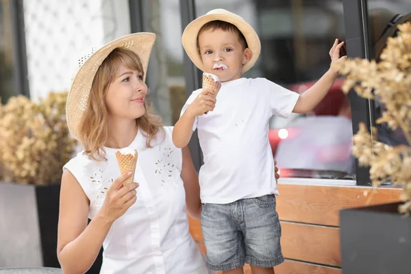 Family of two mom and son eat ice cream while walking together