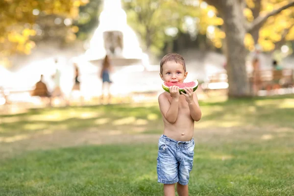 Anak outdoor di taman umum di rumput berjalan dengan sepotong semangka — Stok Foto