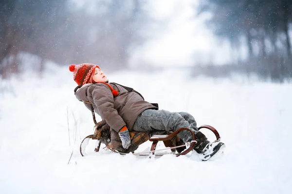 Un niño camina en un claro cubierto de nieve y se divierte en la nieve — Foto de Stock