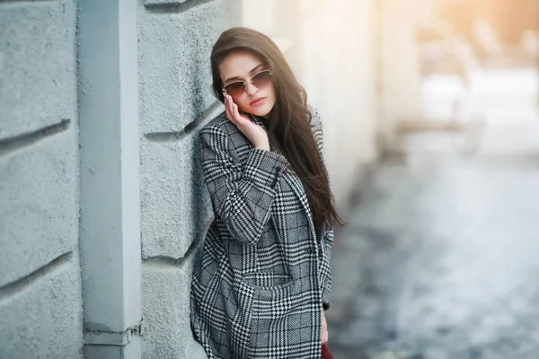 Модель моды женщина с длинными натуральными волосами в теплом пальто прогулки по заснеженным улицам города — стоковое фото