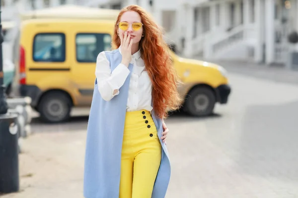 Una estudiante con el pelo amarillo largo y brillante pasea por la ciudad — Foto de Stock