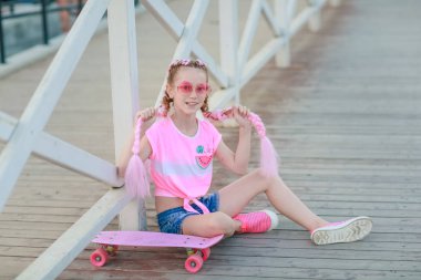 Çocuk aktif açık hava oyunlarından bıktı ve dinlenmek için oturdu.