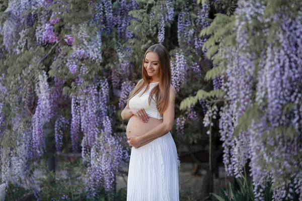 Beautiful future woman mother hugs pregnant belly