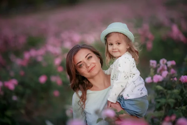 Мать и дочь вместе собирают полевые цветы дикие розы в корзине — стоковое фото