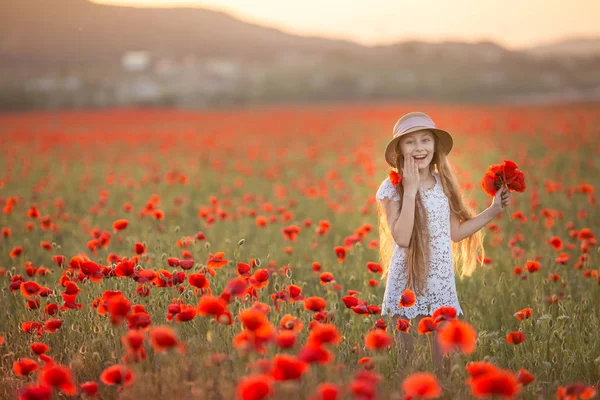 Fille aux cheveux roux 12-13 ans avec des fleurs dans les cheveux sur le fond d'un champ agricole — Photo