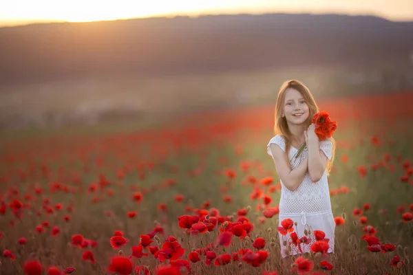 Red-haired girl 12-13 years old with flowers in her hair on the background of an agricultural field — Stock Photo, Image
