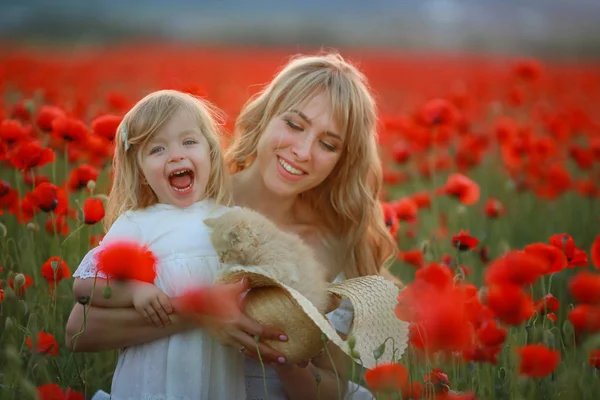 Woman beautiful blonde mom with baby in arms in poppy field — Stock Photo, Image