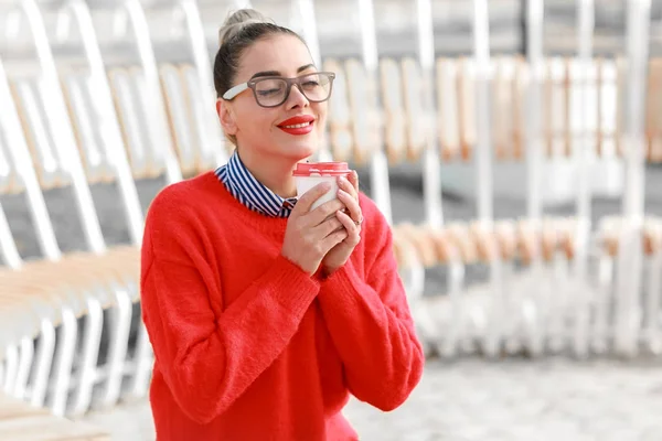 아름다운 여인 이 길가에 안경을 쓰고 앉아서 커피를 마시고 있습니다 — 스톡 사진