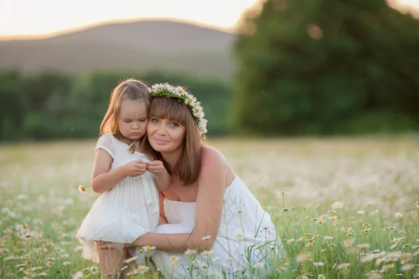 Ung kärleksfull mamma leker med sin dotter utomhus. Barnet är glad och ler. Lycklig familj som springer runt på det gröna gräset, njuter, har kul. Konceptet är en hälsosam livsstil. — Stockfoto