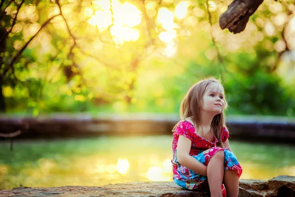 Bella bambina di 5-6 anni seduta nel bosco e sogni di felicità — Foto Stock