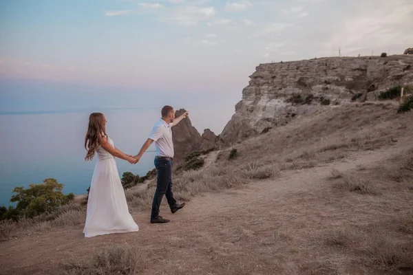 Pár zamilovaný na vrcholu hory na útesu — Stock fotografie