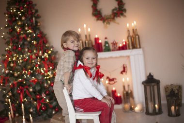 Noel bulmacası, doğal renklerde, erkek ve kız kırmızı Noel odasında.