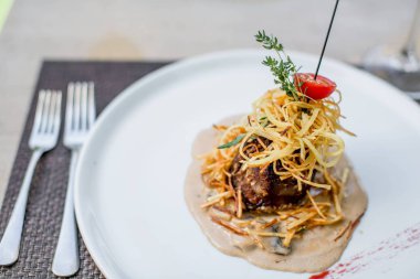 Beyaz tabak, gurme atıştırmalığı ve bir parça et.