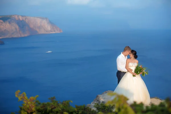 Mladý pár zamilovaný na vrcholu hory nad oceánem — Stock fotografie