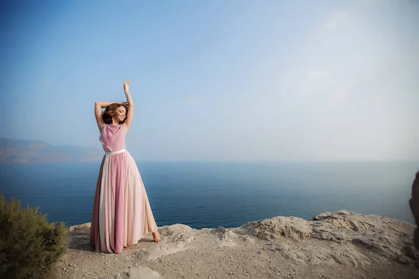 O lugar para inserir o texto. Mulher no topo de uma montanha sobre um mar azul — Fotografia de Stock