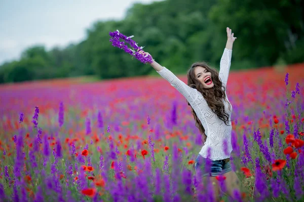 Mujer en la naturaleza en un campo con flores púrpuras —  Fotos de Stock