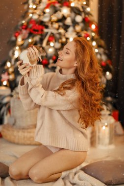 Beyaz kadın elinde dekoratif bir fare tutuyor, fareye yakın duruyor. 2020 yeni yıl sembolü.