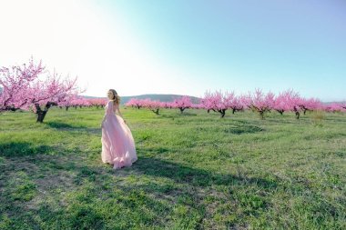 Bahçede uzun gelinlikli bir kadın.