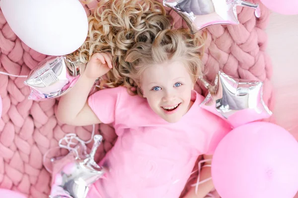 Dívka v růžovém pokoji a růžové oblečení na pozadí balónky — Stock fotografie