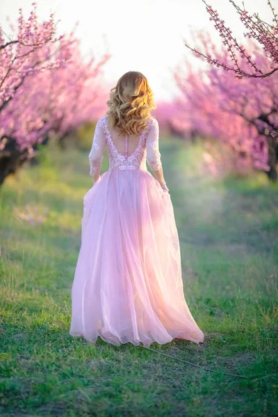 Fullängds utomhus modell i en trädgård i naturen i rosa färger. — Stockfoto