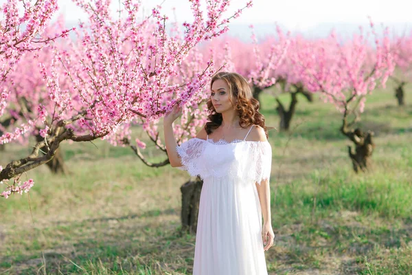 Una mujer hermosa en un vestido largo blanco como una novia en un parque público —  Fotos de Stock