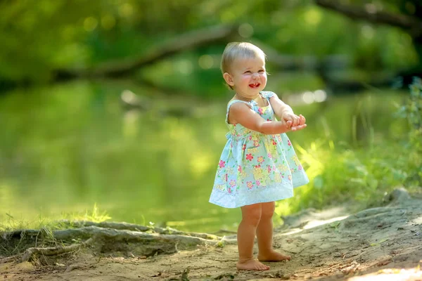 Dívka dítě jeden bosý u vody v lese — Stock fotografie