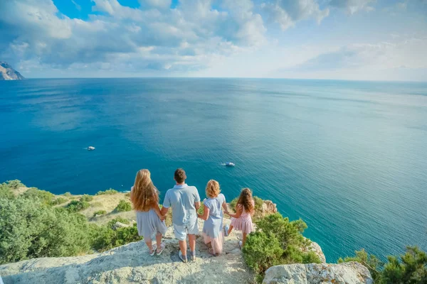 Egy teljes család négy anyából és két lányból egy hegytetőn a tenger felett. — Stock Fotó