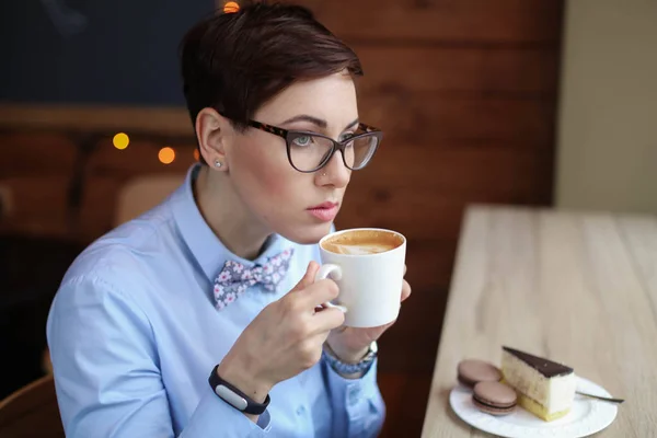 Primer plano de una mujer con el pelo corto y una taza de café en las manos —  Fotos de Stock