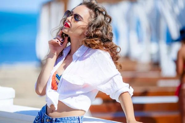 Schönes weibliches Modell mit Sonnenbrille im Urlaub am Meer — Stockfoto