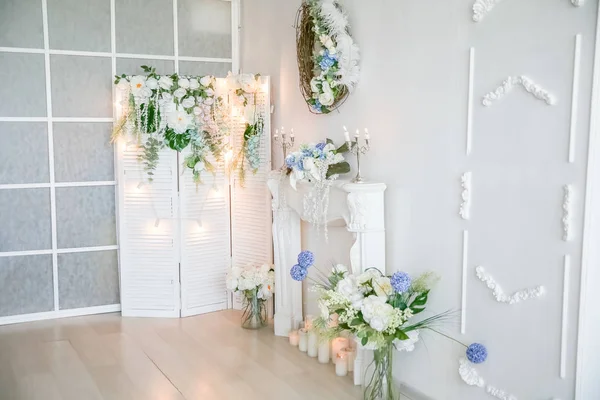 Chimenea blanca artificial decorada con velas y flores artificiales — Foto de Stock