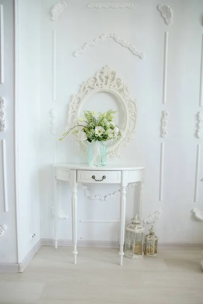 Ett Versailles bord mot en vit vägg med en vas blommor på bordet — Stockfoto