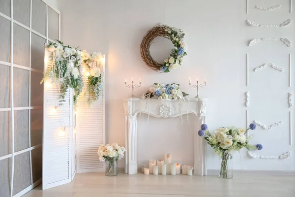 Caminetto bianco artificiale decorato con candele e fiori artificiali — Foto Stock