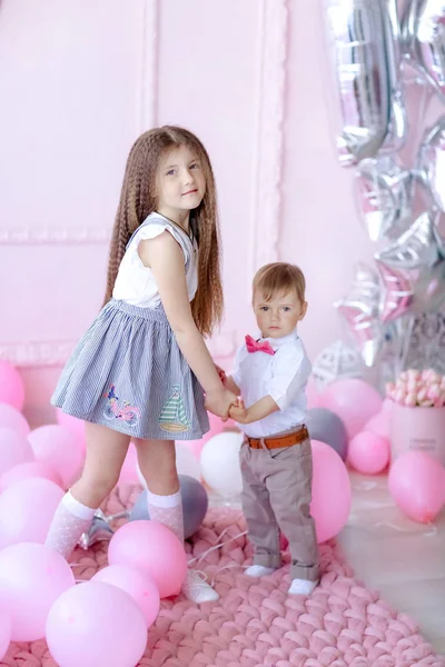 Irmão e irmã crianças no aniversário no quarto das crianças decorado com balões rosa — Fotografia de Stock