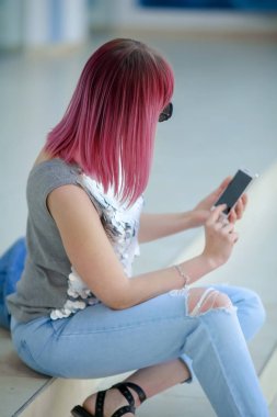 Renkli saçlı hippi kadın cep telefonu kullanıyor.