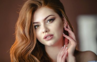 Kızıl saçlı genç bir mankenin portresi.