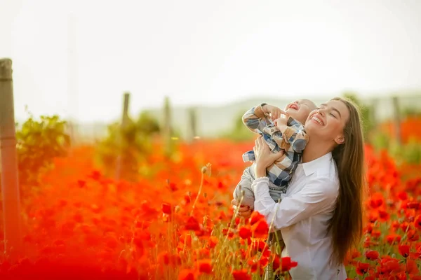 Close-up of a mother with a child in a field with poppies. Copy space — ストック写真