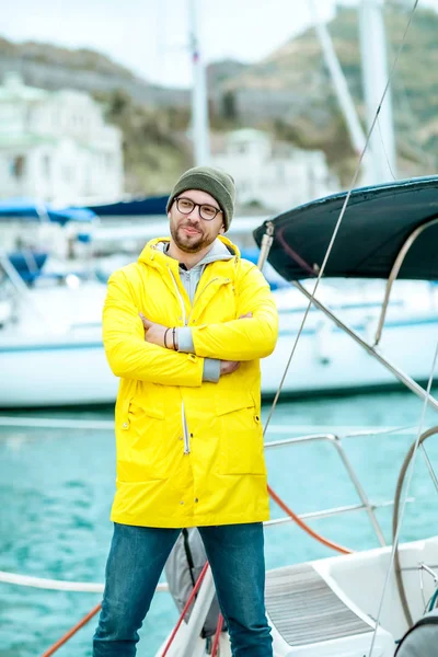 Un hombre un náutico o un marinero en el muelle se encuentra cerca de un barco de mar — Foto de Stock