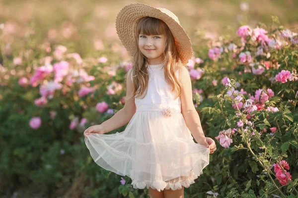 Menina em um vestido branco em um chapéu quebrado em um campo de lavanda — Fotografia de Stock