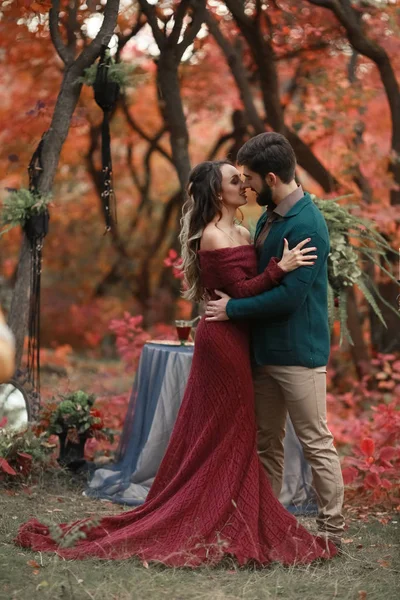 Un homme amoureux lors d'un rendez-vous romantique avec une femme vêtue d'une élégante robe longue dans la forêt — Photo