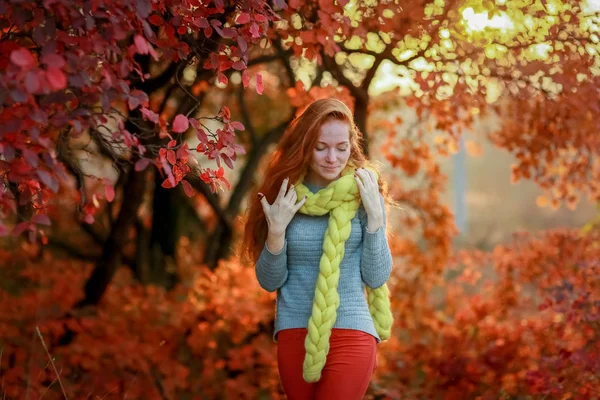 Mulher de cabelos vermelhos na floresta com folhas vermelhas caindo em um lenço amarelo quente — Fotografia de Stock