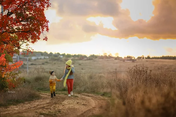 Frère et sœur marchent le long d'une route rurale . — Photo