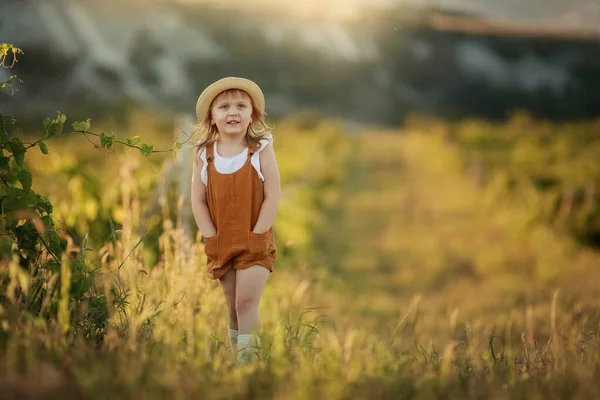 Kleines Mädchen läuft auf grünem Gras. schöner warmer Sommerabend. — Stockfoto