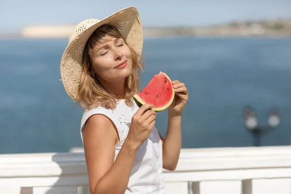 夏天，一个穿着白衬衫，手里拿着一片西瓜的女人 — 图库照片